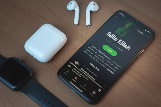 Persona che ascolta musica con cuffie collegata a smartphone